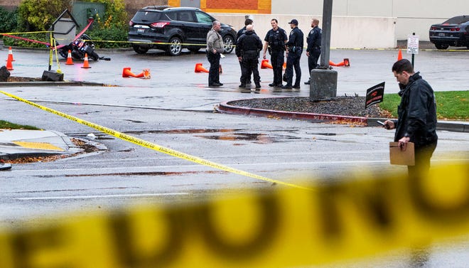 Authorities collect evidence in a parking lot near a shopping mall after a shooting Monday in Boise, Idaho.