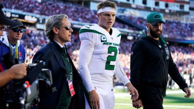 New York Jets quarterback Zach Wilson is escorted to the locker room after an apparent injury during the first half of an NFL football game against the New England Patriots on October 24 in Foxborough, Massachusetts.