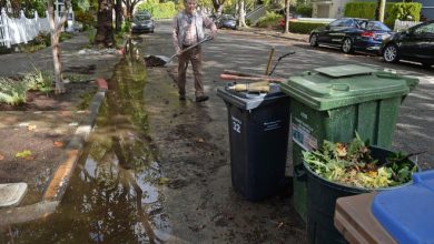 Robert Schmidt cleans up after Saturday's storm in front of his home on C Street in San Rafael, Calif., on Monday, Oct. 25, 2021. During the storm, the street was under water, with several inches of water entering Schmidt's garage.