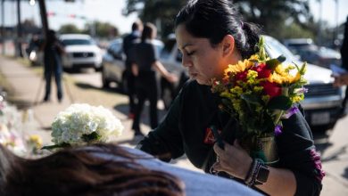 Ericka Medina places flowers at a growing memorial in front of NRG Park on Sunday, Nov. 7, 2021, in Houston, Texas.