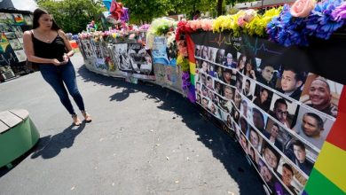 A visitor looks over a display with the photos and names of the 49 victims that died at the Pulse nightclub.