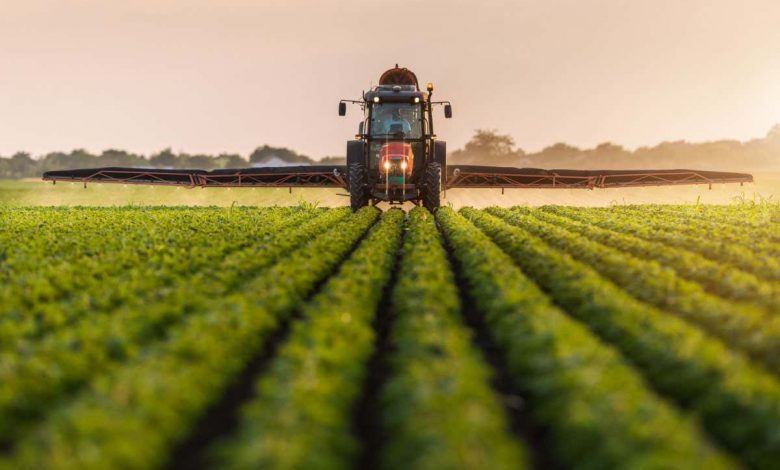 Tractor spraying pesticides on soybean field with sprayer at spring; Shutterstock ID 692043769; purchase_order: -; job: -; client: -; other: -