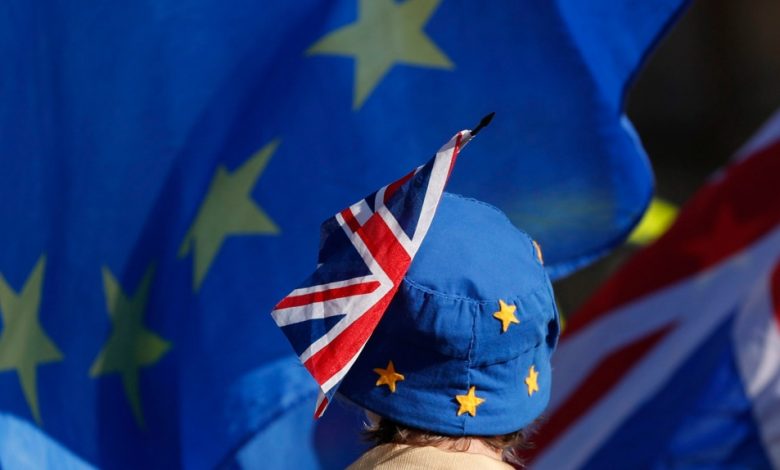 In this Oct. 16, 2018, file photo, a pro-EU demonstrator wears an EU flag styled as a hat, with a British Union flag pinned to it in London. (AP Photo/Alastair Grant, File)