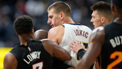 Denver Nuggets' Nikola Jokic, centre, is restrained by Miami Heat guards Kyle Lowry, left, and Tyler Herro after knocking over Heat forward Markieff Morris during a game on Nov. 8, 2021. (David Zalubowski / AP)