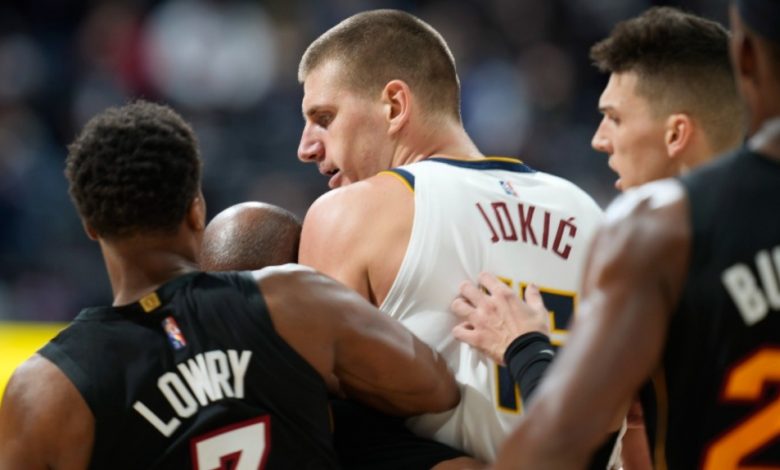 Denver Nuggets' Nikola Jokic, centre, is restrained by Miami Heat guards Kyle Lowry, left, and Tyler Herro after knocking over Heat forward Markieff Morris during a game on Nov. 8, 2021. (David Zalubowski / AP)
