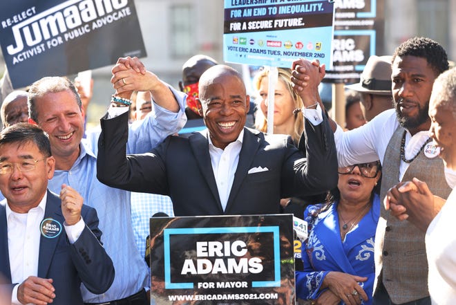 Eric Adams raises hands with Jumaane Williams, New York City Public Advocate, and Comptroller candidate Brad Lander during a Get Out the Vote rally in front of Brooklyn Borough Hall on October 22, 2021.
