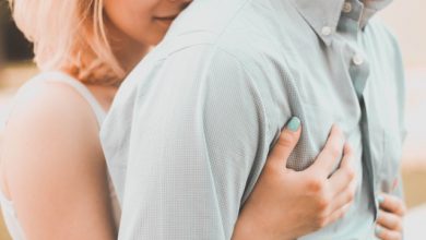 woman hugging a man from behind, hands on chest