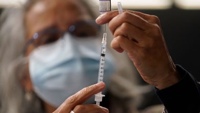 Dr. Manjul Shukla transfers Pfizer COVID-19 vaccine into a syringe on Thursday, Dec. 2, 2021, at a mobile vaccination clinic in Worcester, Massachusetts.