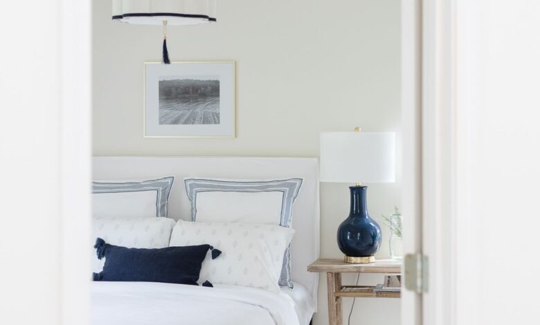 art over bed in a white and navy blue guest room