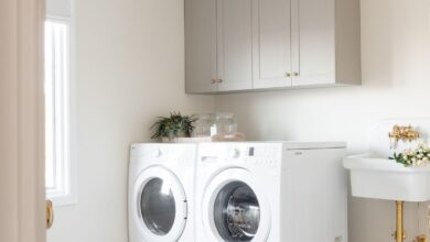 A laundry room with greige cabinets, a wall sink and herringbone floor.