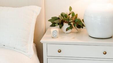 A primary bedroom with white bedding and simple nightstand decorating