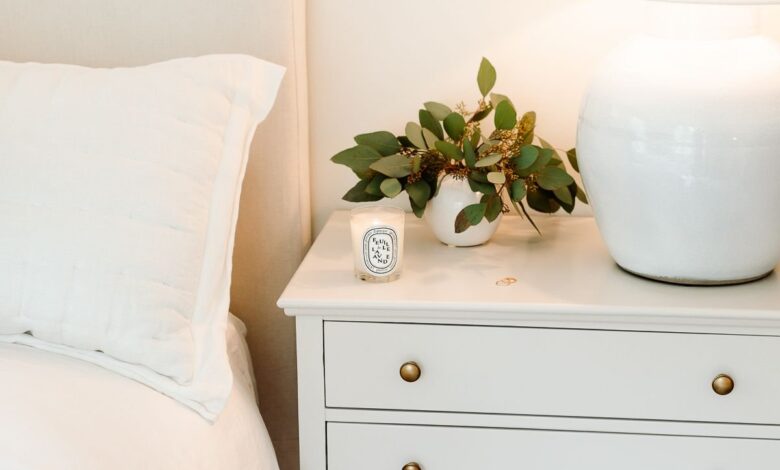 A primary bedroom with white bedding and simple nightstand decorating