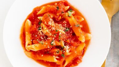 A plate of penne arrabbiata, topped with grated pecorino