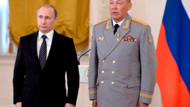 In this pool photo taken on Thursday, March 17, 2016, Russian President Vladimir Putin, left, poses with Col. Gen. Alexander Dvornikov during an awarding ceremony in Moscow's Kremlin, Russia.