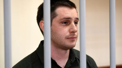 US ex-marine Trevor Reed, charged with attacking police, stands inside a defendants' cage during a court hearing in Moscow, Russia, on March 11, 2020.