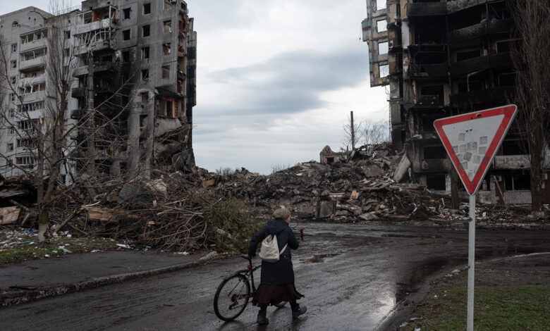 A woman walks near a destroyed apartment building on April 9 in Borodianka, Ukraine.