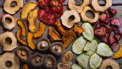 Assortment of dehydrated fruits and vegetables on wooden background.