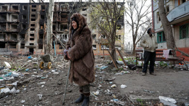 Local residents stand in a courtyard near a destroyed residential building in Mariupol, Ukraine, on Sunday, April 17.