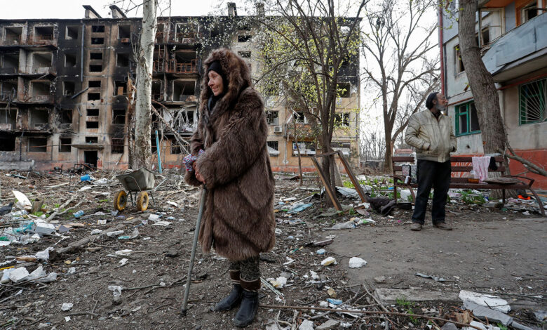 Local residents stand in a courtyard near a destroyed residential building in Mariupol, Ukraine, on Sunday, April 17.