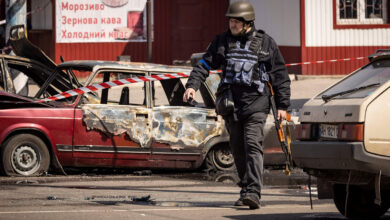 A Ukrainian policeman walks past damaged vehicles outside a train station in Kramatorsk, Ukraine, on April 8.