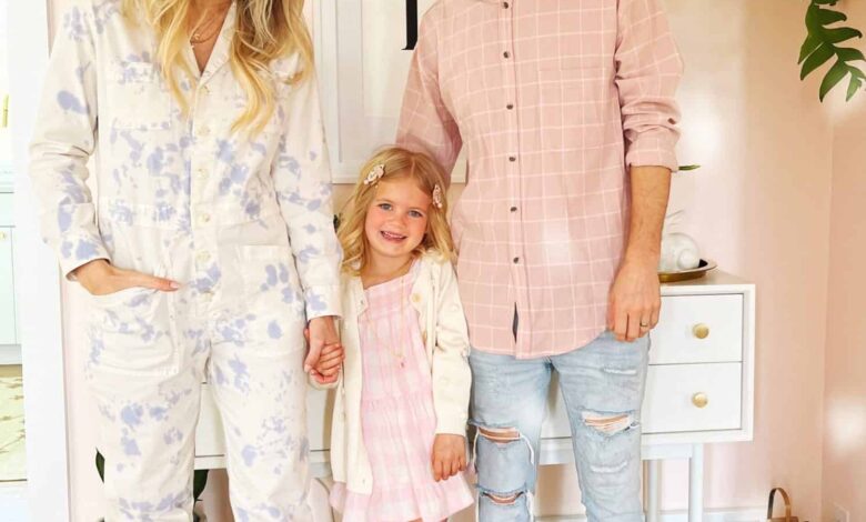 mom, daughter, and dad in their home in pastel clothing