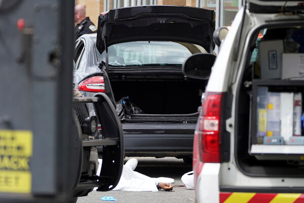 A body lies in the parking lot of a supermarket in Buffalo, where 10 people were killed in a shooting on Saturday.