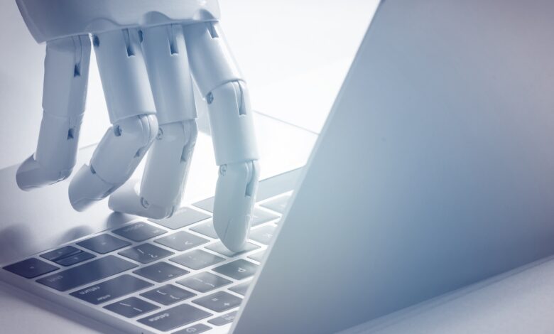 Chat bot , artificial intelligence , robo advisor , robotic concept. Robot finger point to laptop button. Blue tone.