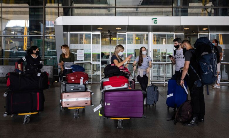 Passengers wearing face masks arrive at Adolfo Suarez-Barajas international airport, outskirts Madrid, Spain, Sunday, June 21, 2020. Spain opened its borders to European tourists on Sunday in a bid to kickstart its vital tourism economy, but Brazil and South Africa reported record new levels of coronavirus infections. (AP Photo/Bernat Armangue)