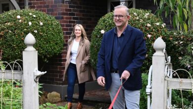 Australia's Prime Minister-elect Anthony Albanese, right, and his partner Jodie Haydon go for a walk with their dog, Toto, in Sydney, Sunday, May 22, 2022. Albanese has promised to rehabilitate Australia's international reputation as a climate change laggard with steeper cuts to greenhouse gas emissions. (Dean Lewins/AAP Image via AP)