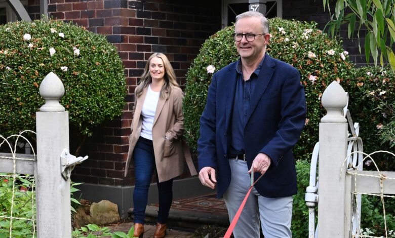 Australia's Prime Minister-elect Anthony Albanese, right, and his partner Jodie Haydon go for a walk with their dog, Toto, in Sydney, Sunday, May 22, 2022. Albanese has promised to rehabilitate Australia's international reputation as a climate change laggard with steeper cuts to greenhouse gas emissions. (Dean Lewins/AAP Image via AP)