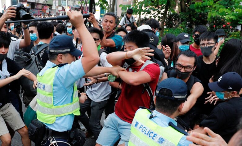Police swing their batons at pro-democracy protesters at Sheung Shui