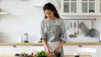 women chopping vegetables in kitchen