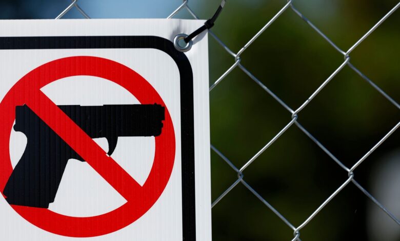 A detail view of a sign indicating no guns allowed is displayed on a fence, Sunday, June 19, 2022, in Houston. (Aaron M. Sprecher via AP)