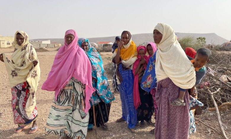 Women of the village of Gideis gather outside the hut of a severely ill baby and mother
