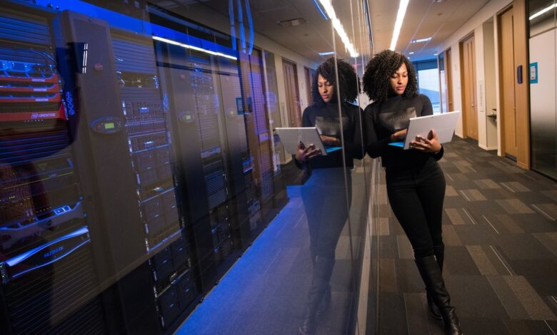 A woman inspects servers on a laptop computer.