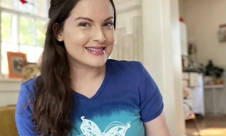Girl posing in living room wearing a blue butterfly shirt