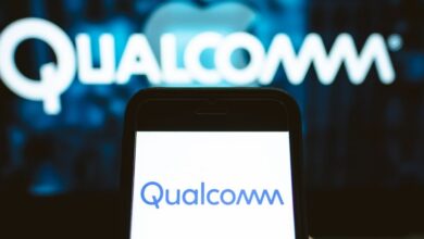 User holds a smartphone displaying Qualcomm