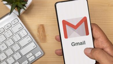 Hand Holding and tapping smartphone with Gmail Logo on it with according text.