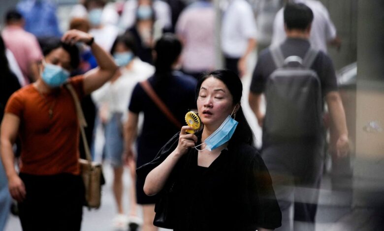 A woman uses a fan to cool down in Shanghai