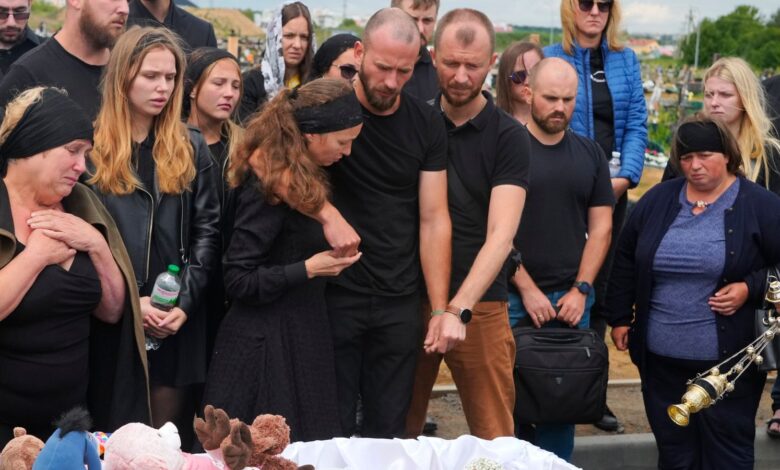Relatives and friends react near the coffin during a funeral ceremony for Liza, 4-year-old girl killed by Russian attack, in Vinnytsia, Ukraine, Sunday, July 17, 2022. Wearing a blue denim jacket with flowers, Liza was among 23 people killed, including 2 boys aged 7 and 8, in Thursday's missile strike in Vinnytsia. Her mother, Iryna Dmytrieva, was among the scores injured. (AP Photo/Efrem Lukatsky)