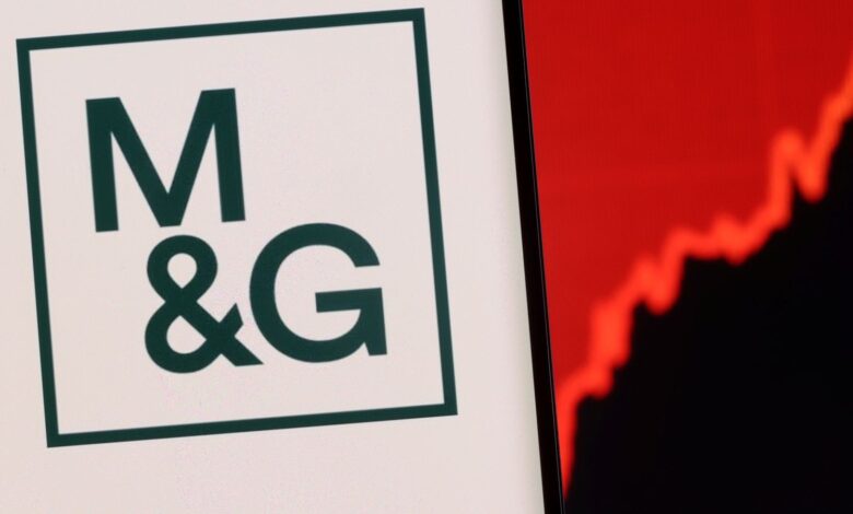M&G plc logo is seen on a smartphone in front of displayed stock graph in this illustration taken, December 1, 2021. REUTERS/Dado Ruvic/Illustration
