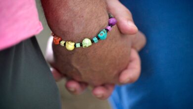 An attendee wears a bracelet with LGBTQ Pride colors during the Six-Year Pulse Remembrance Ceremony outside The Pulse Interim Memorial, Sunday, June 12, 2022, in Orlando, Fla. (Phelan M. Ebenhack via AP)