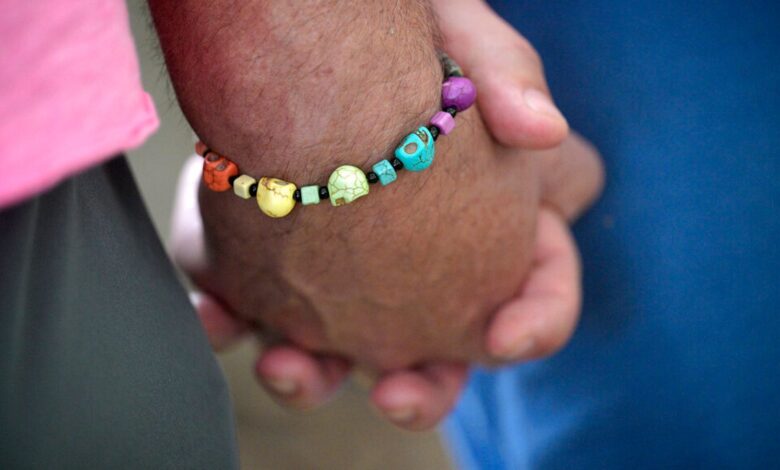 An attendee wears a bracelet with LGBTQ Pride colors during the Six-Year Pulse Remembrance Ceremony outside The Pulse Interim Memorial, Sunday, June 12, 2022, in Orlando, Fla. (Phelan M. Ebenhack via AP)