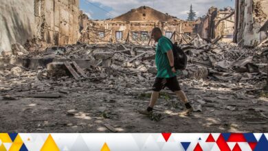 A local resident walks in a front of a building destroyed by a military strike, as Russia's attack on Ukraine continues, in Lysychansk