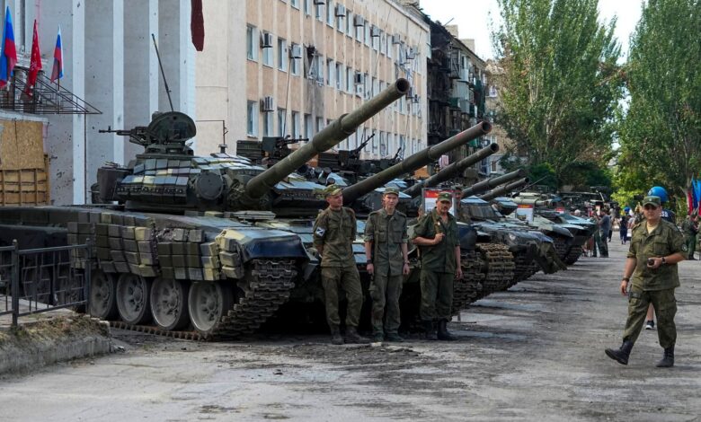 Luhansk People's Republic people militia servicemen stand at an exhibition of captured Ukrainian tanks and weapons in Lisichansk, on the territory which is under the Government of the control, eastern Ukraine, Tuesday, July 12, 2022. This photo was taken during a trip organized by the Russian Ministry of Defense. (AP Photo)