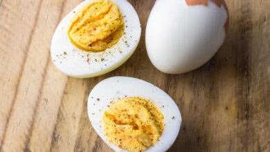 Boiled chicken eggs on wooden board with pepper flakes