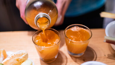 Pouring apple cider vinegar into shot glasses