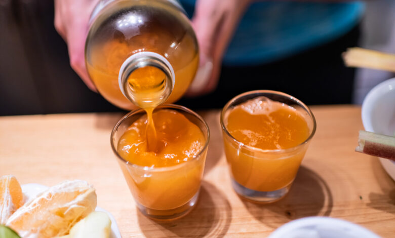 Pouring apple cider vinegar into shot glasses
