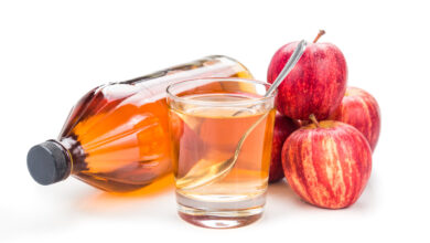 Apple cider vinegar in jar, glass and fresh apples.