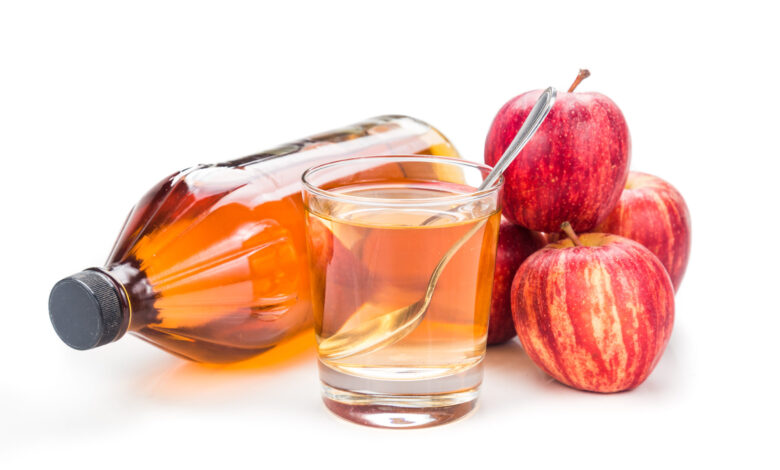 Apple cider vinegar in jar, glass and fresh apples.